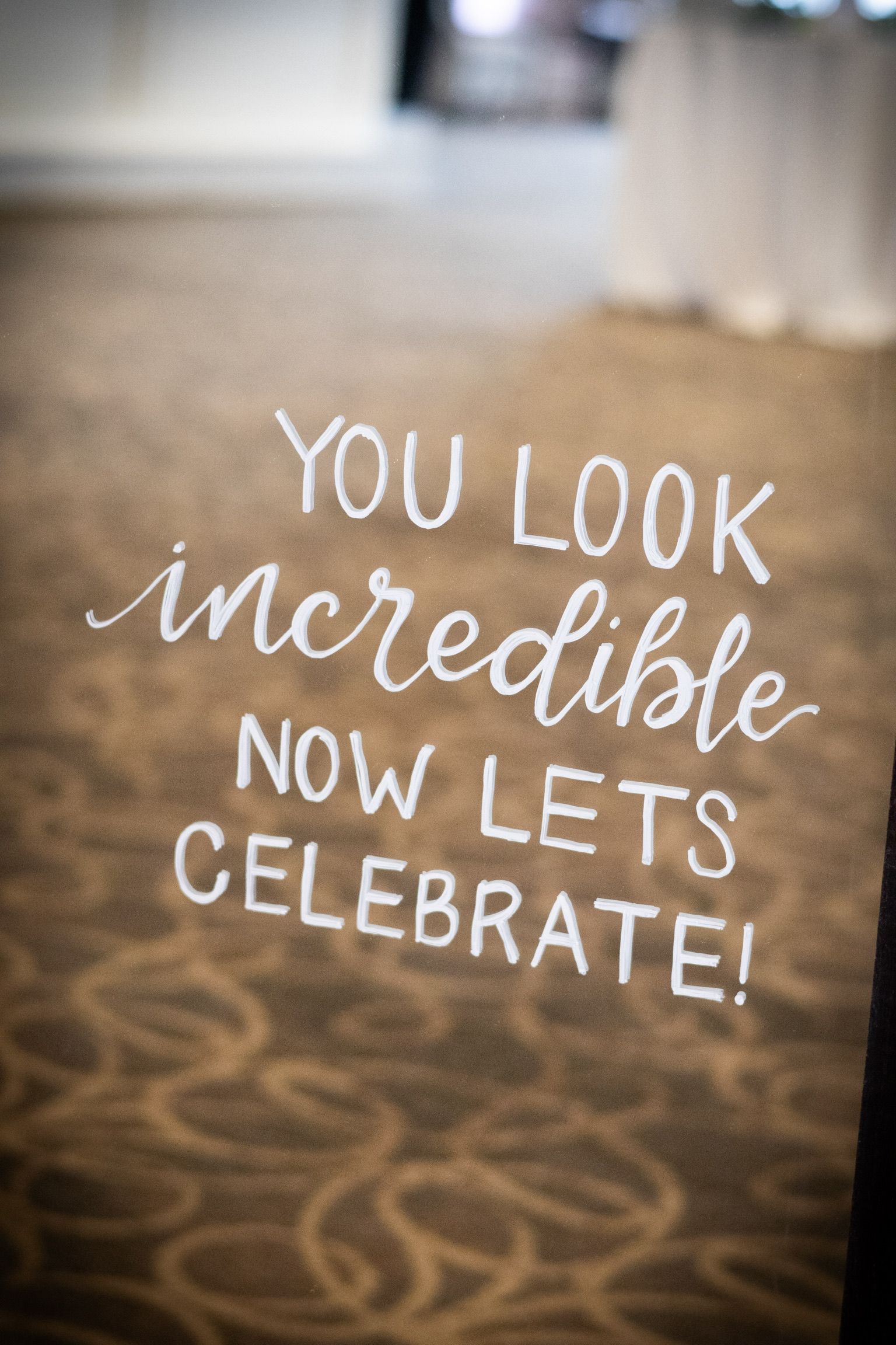 White handwritten text on a clear surface reads, 