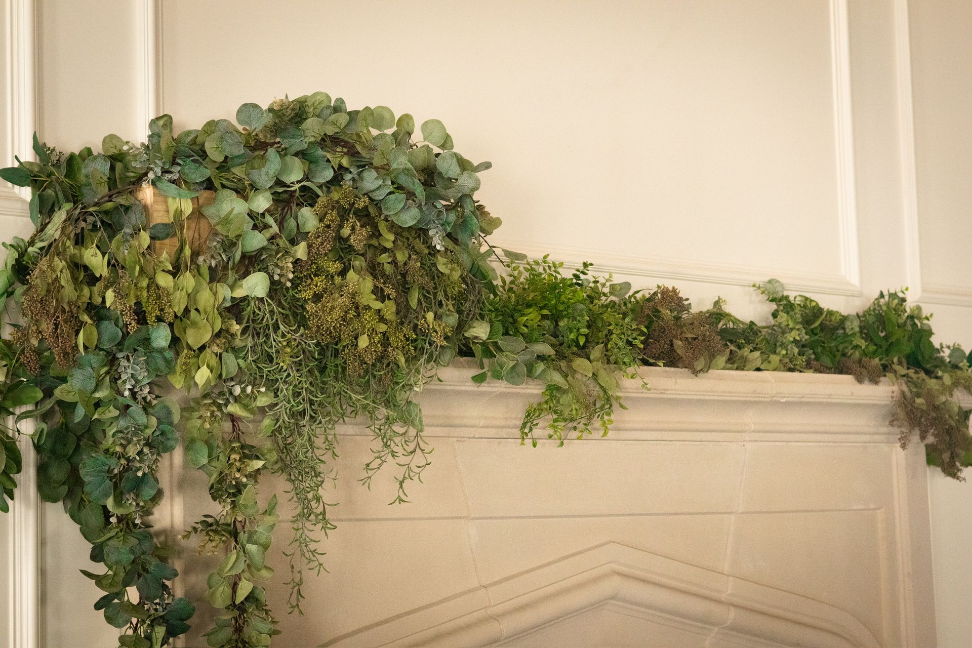 Greenery garland on a stone fireplace mantel.