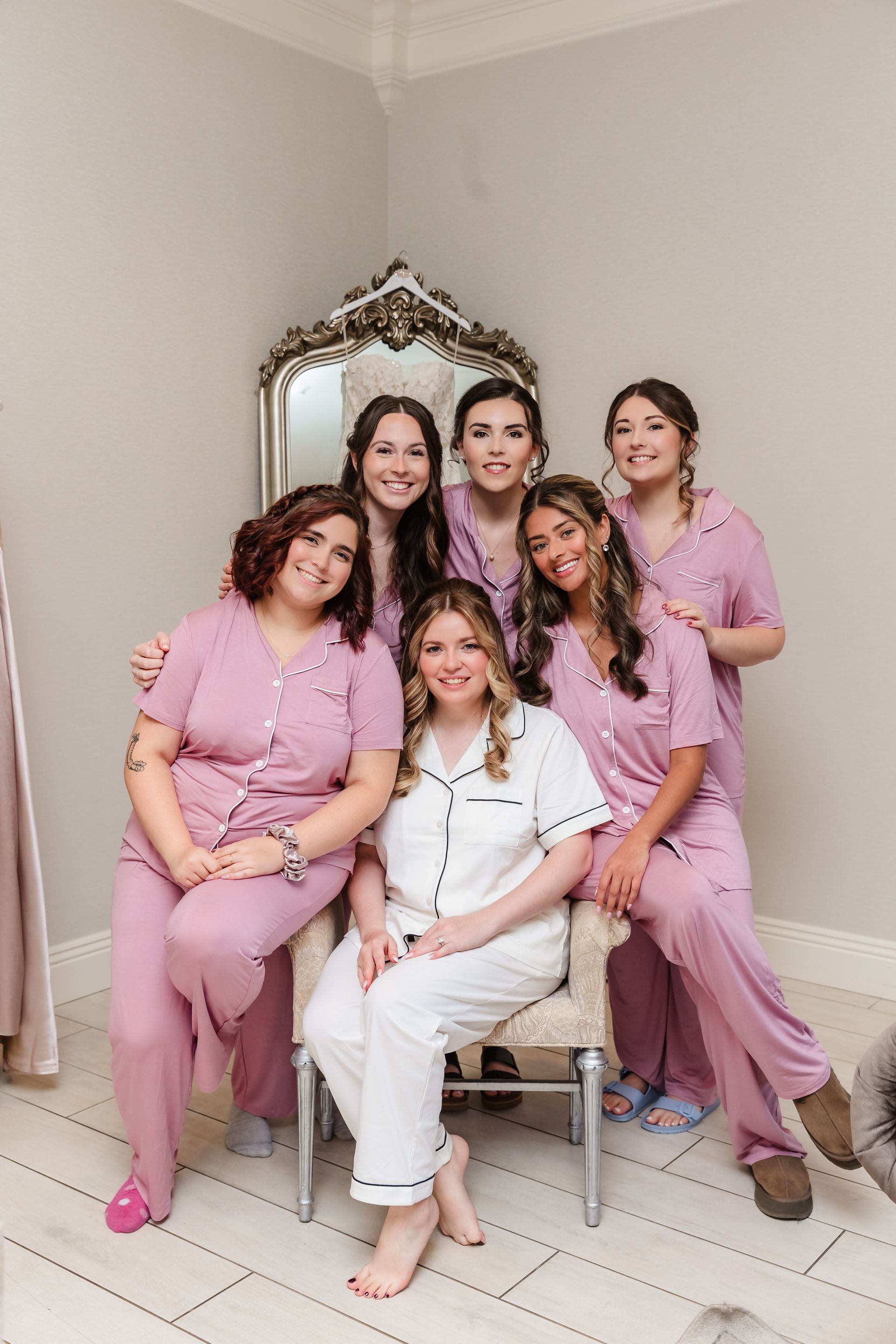 Six people in pajamas posing in a room. One person seated, others standing. All smiling.