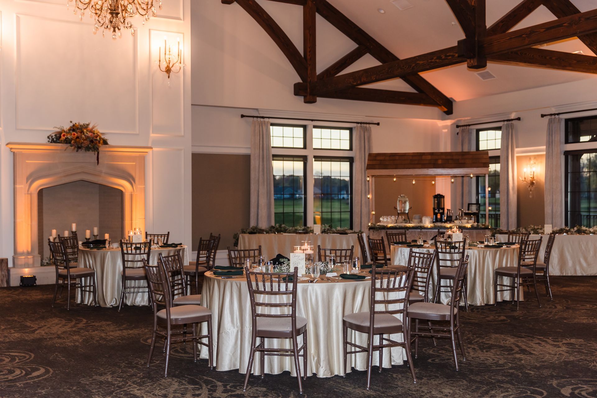 Formal event space with round tables set for dining, fireplace, and bar area.