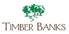 Timber Banks logo: Green trees with a red flag over a winding path; brown text "Timber Banks".