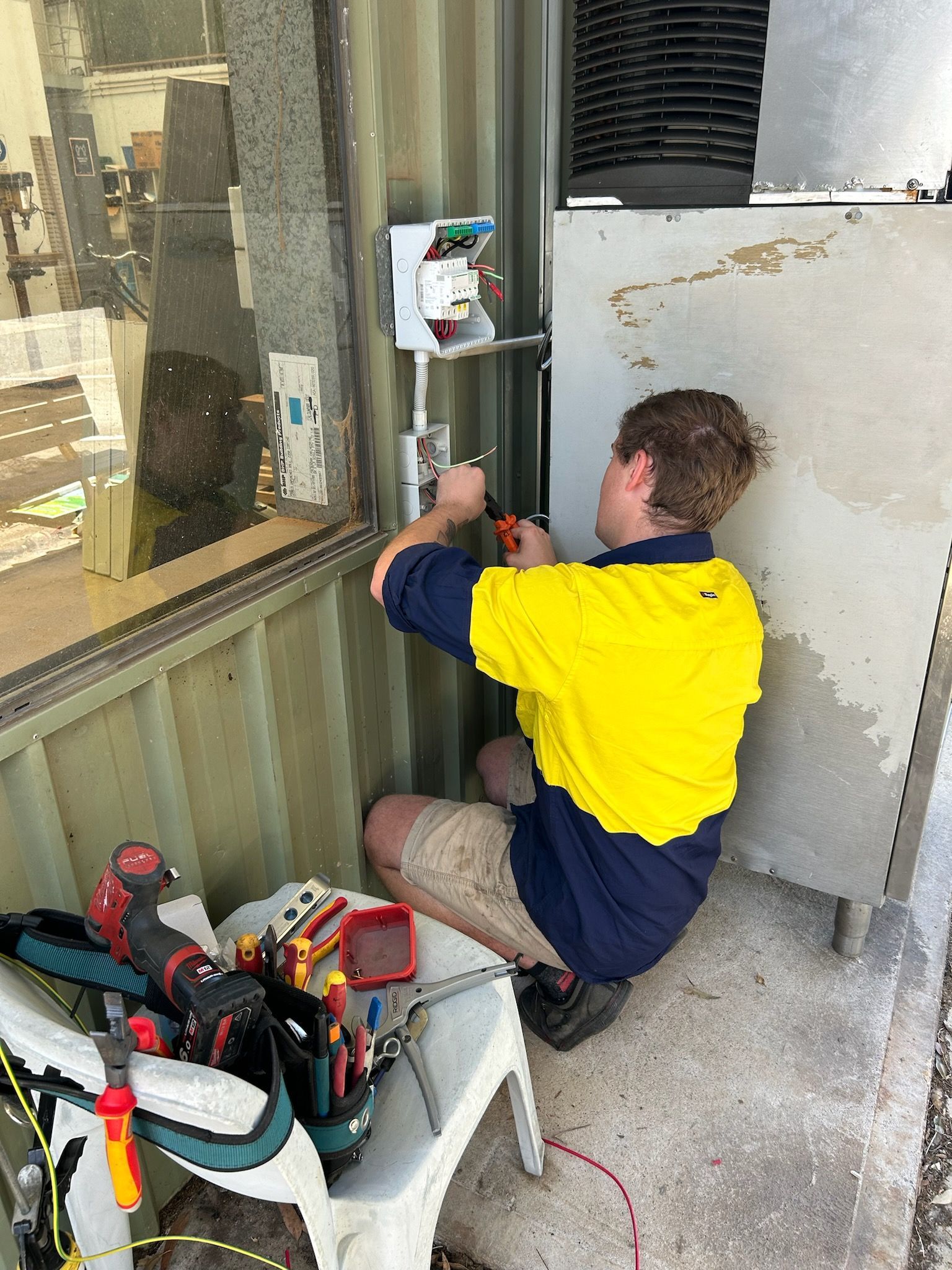 Male Technician Repairing Refrigerator Indoors — Mingleford Electrical Airconditioning Solar & Gas In Landsborough, QLD