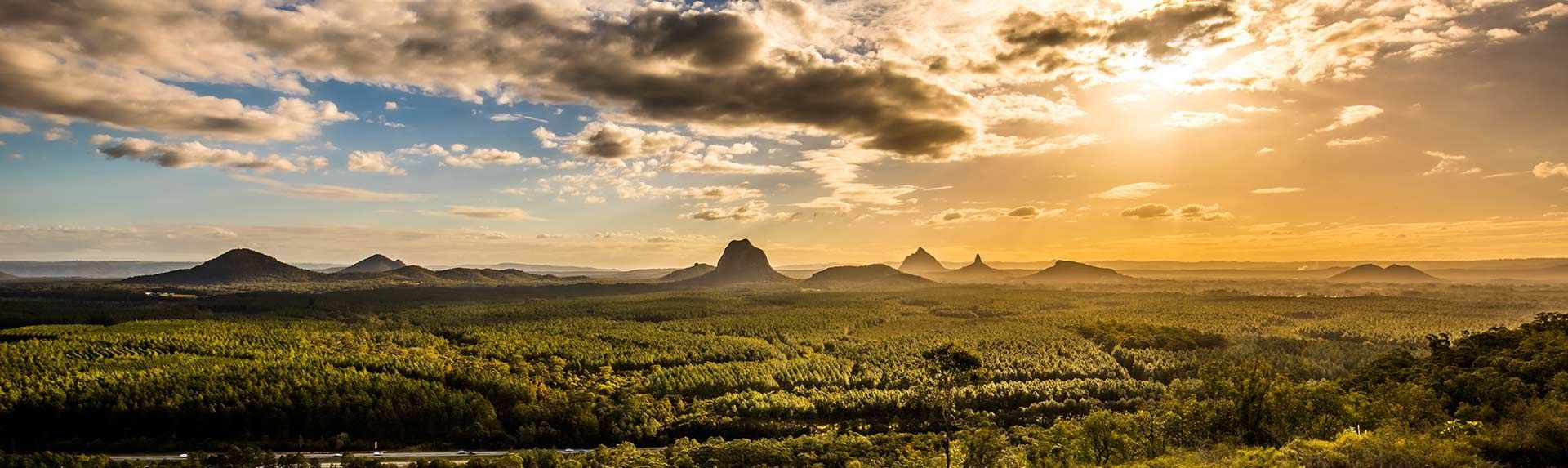 Sun Is Shining Through The Clouds Over A Lush Green Field — Mingleford Electrical Airconditioning Solar & Gas In Kenilworth, QLD