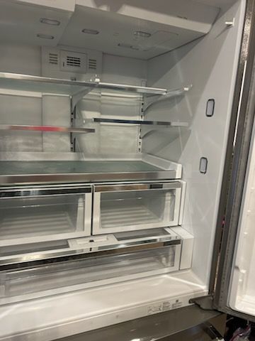 The inside of an empty refrigerator with the door open.