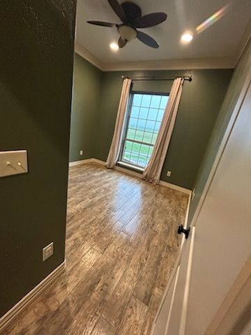 There is a ceiling fan in the room with a window.