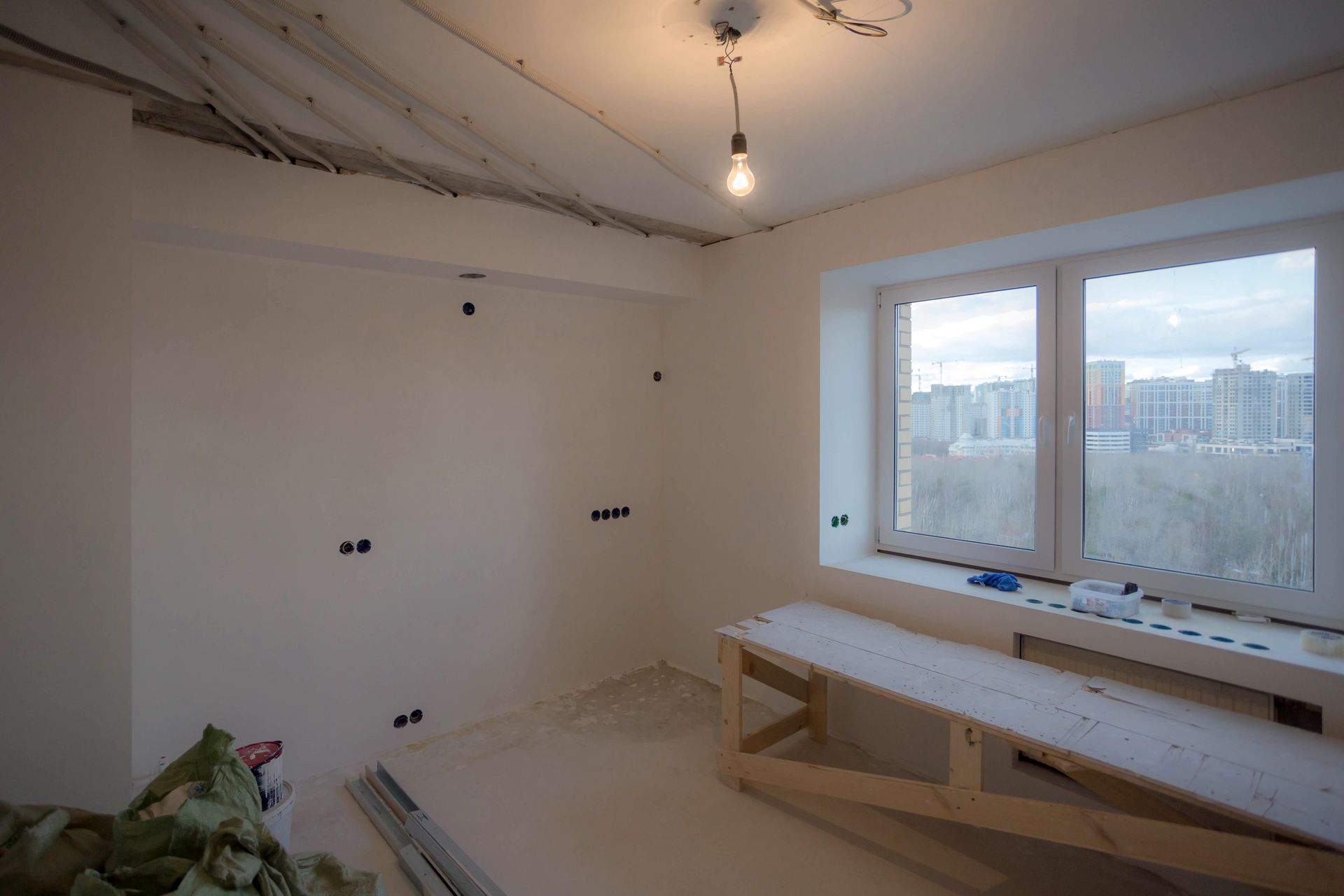 An empty room with a wooden bench and a window.