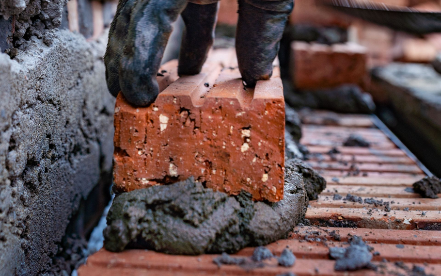 Red brick wall with staggered horizontal rows and light gray mortar lines