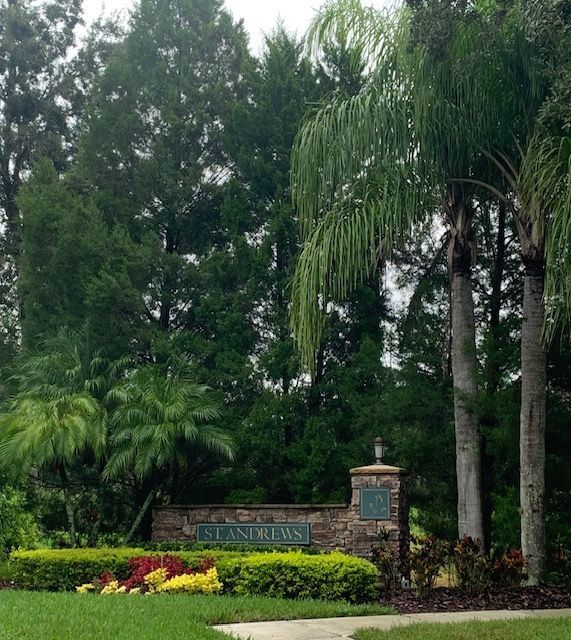 A stone wall with a sign that says ' standrews ' on it