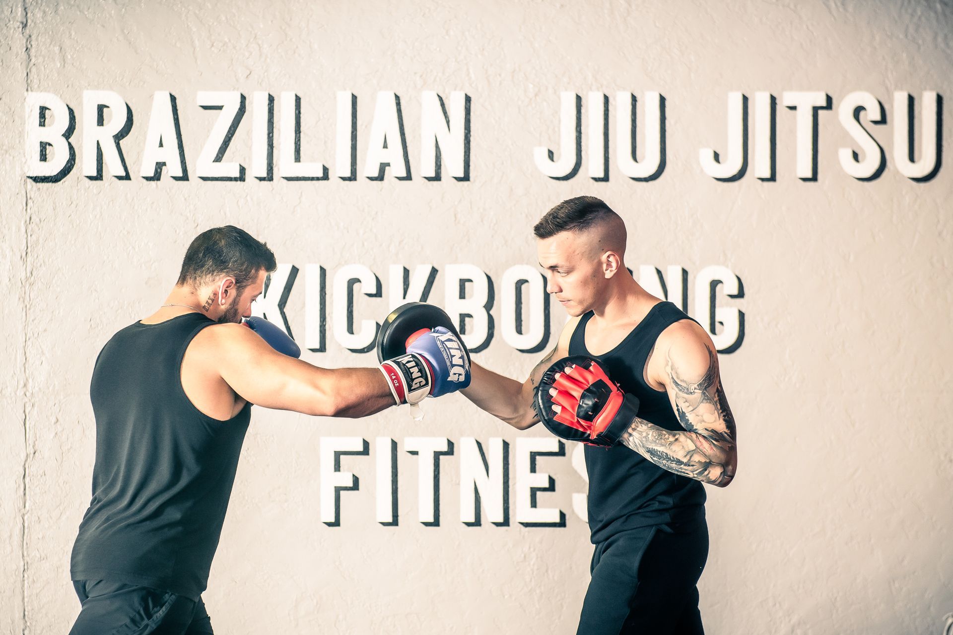Two men boxing, sparring in a fitness studio with 