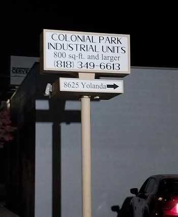 A tall sign at night showing the text “Colonial Park Industrial Units, 800 sq-ft and larger, (818) 349-6613” 