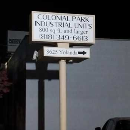 A tall sign at night showing the text “Colonial Park Industrial Units, 800 sq-ft and larger, (818) 349-6613” 
