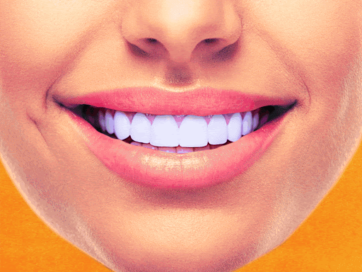 Dentist treating a patient in a dental office. The patient has a dental dam in place.