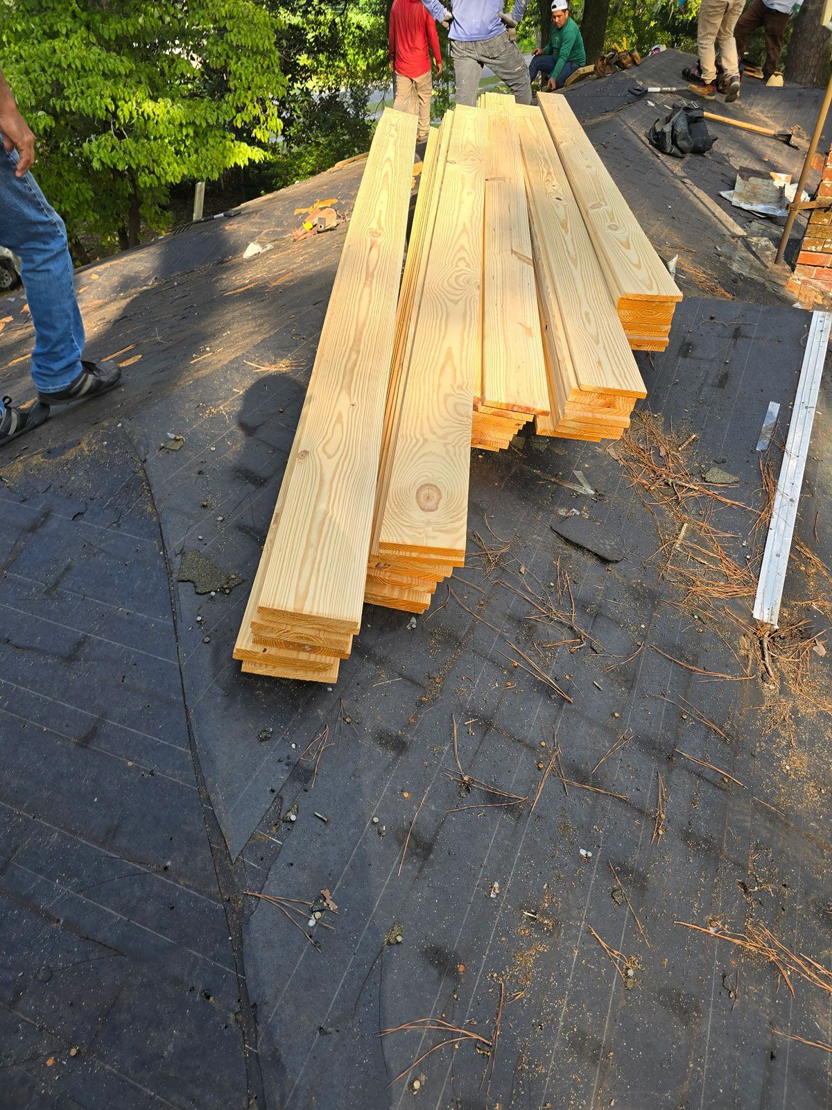 A pile of wood is sitting on top of a roof.
