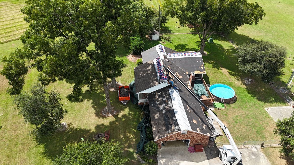 An aerial view of a house being remodeled with a crane.
