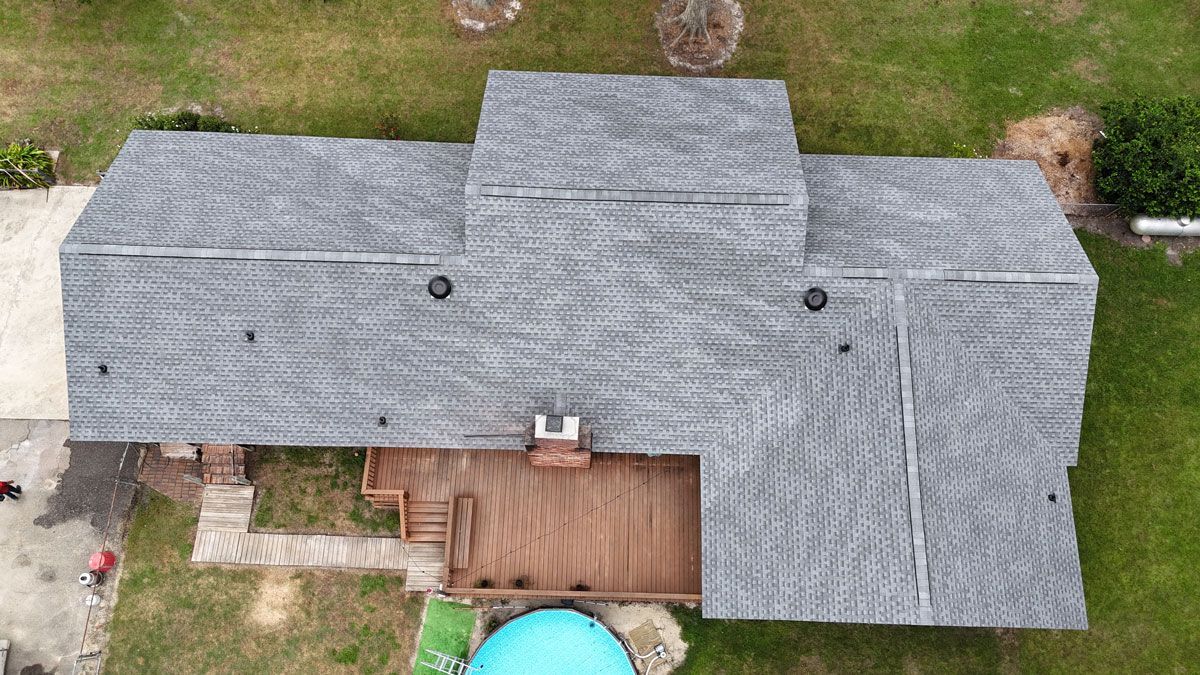 An aerial view of a house with a roof and a pool.