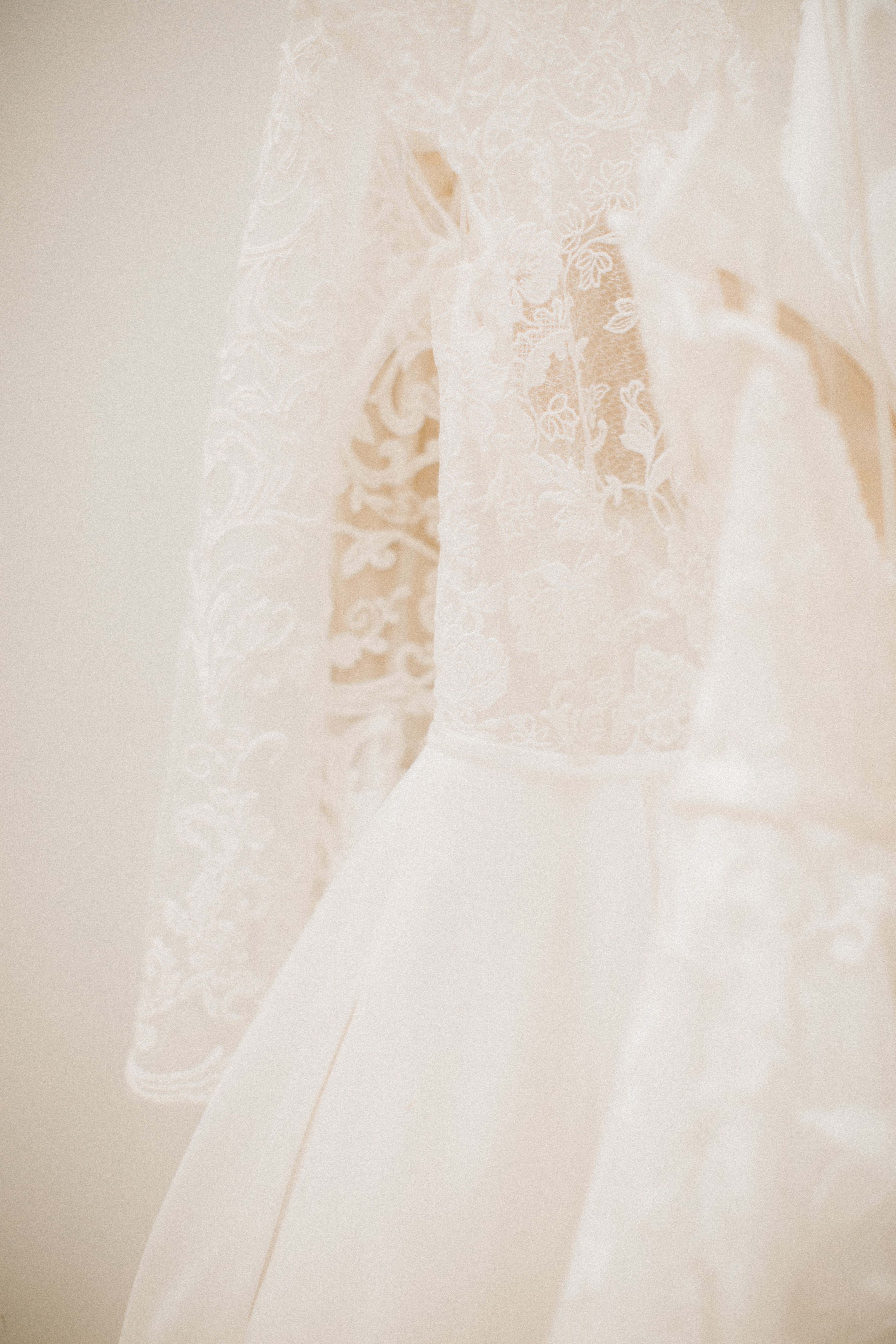 Ivory lace wedding dress on a mannequin, with a white fur wrap draped over it.