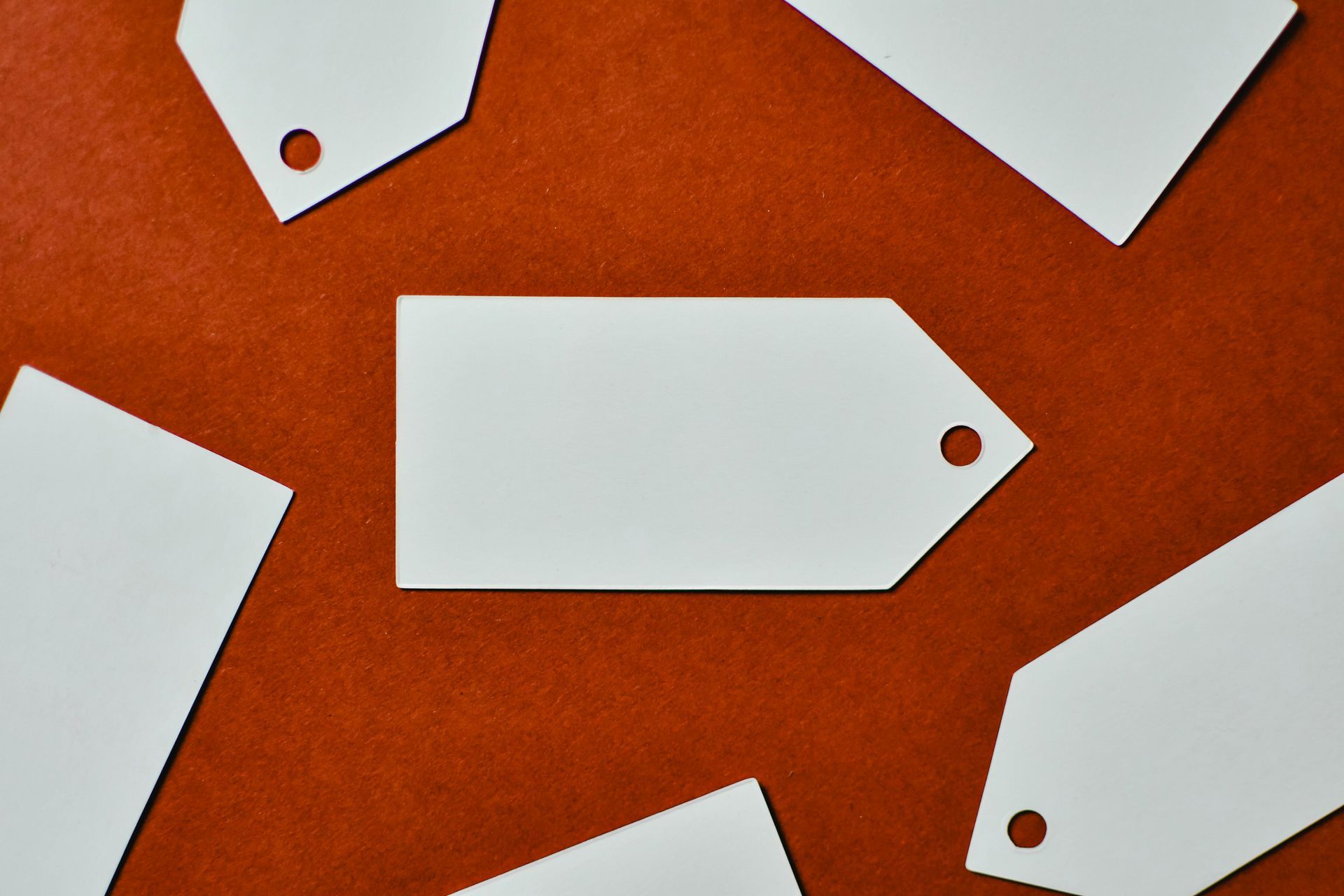 White price tags scattered on an orange background