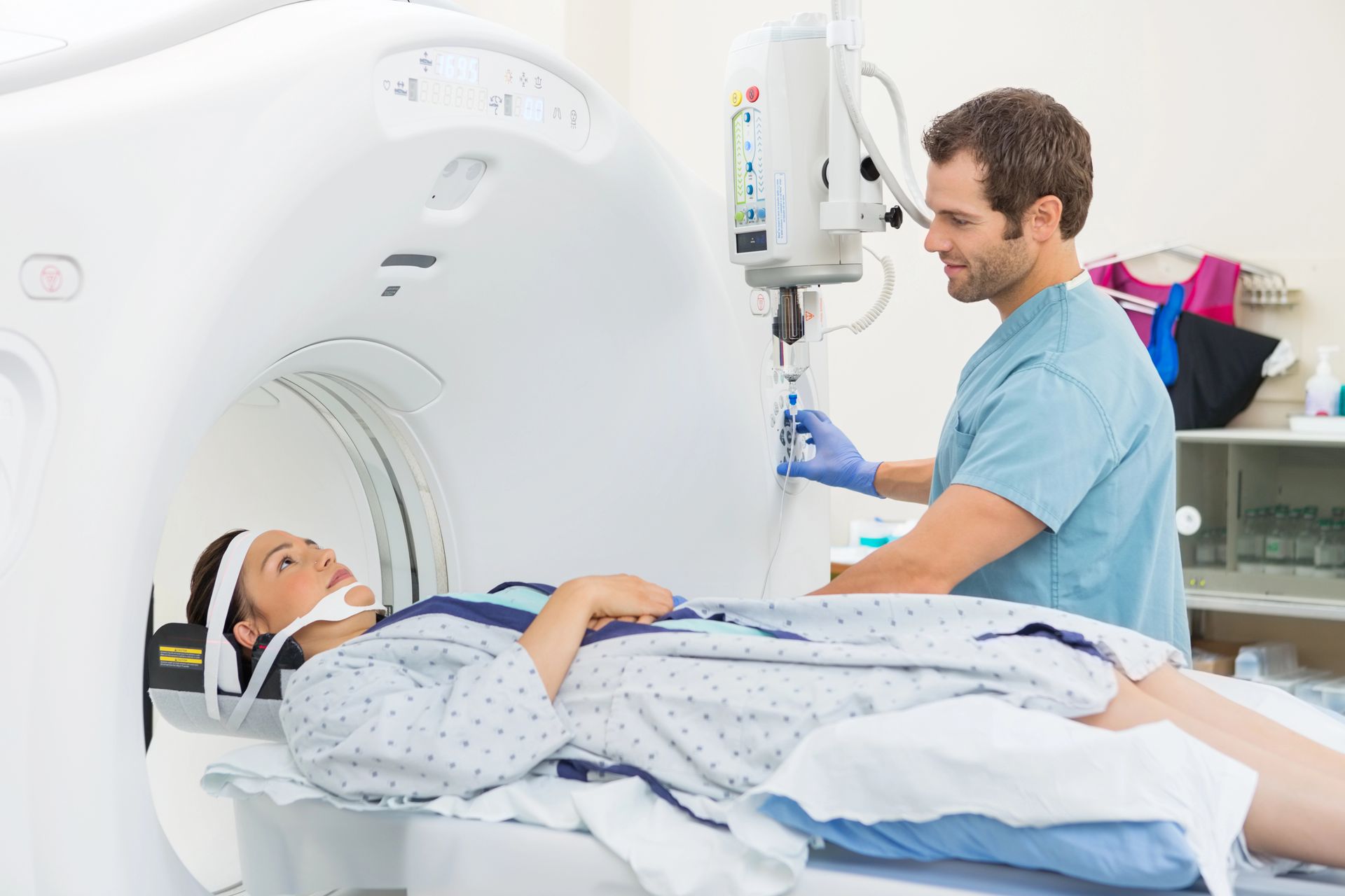 Una mujer está acostada en una cama de hospital y le están haciendo una tomografía computarizada.