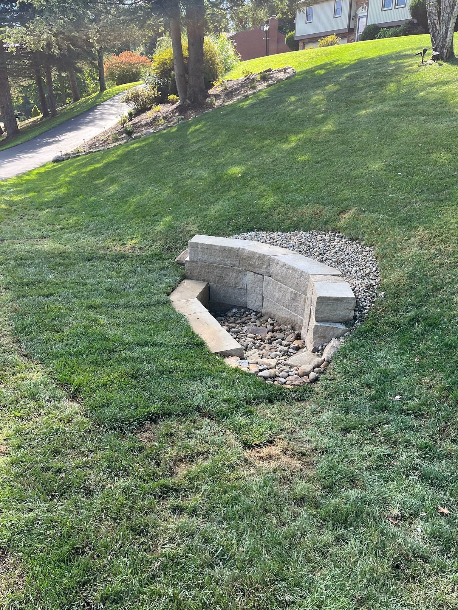 A fire pit is sitting in the middle of a lush green lawn.