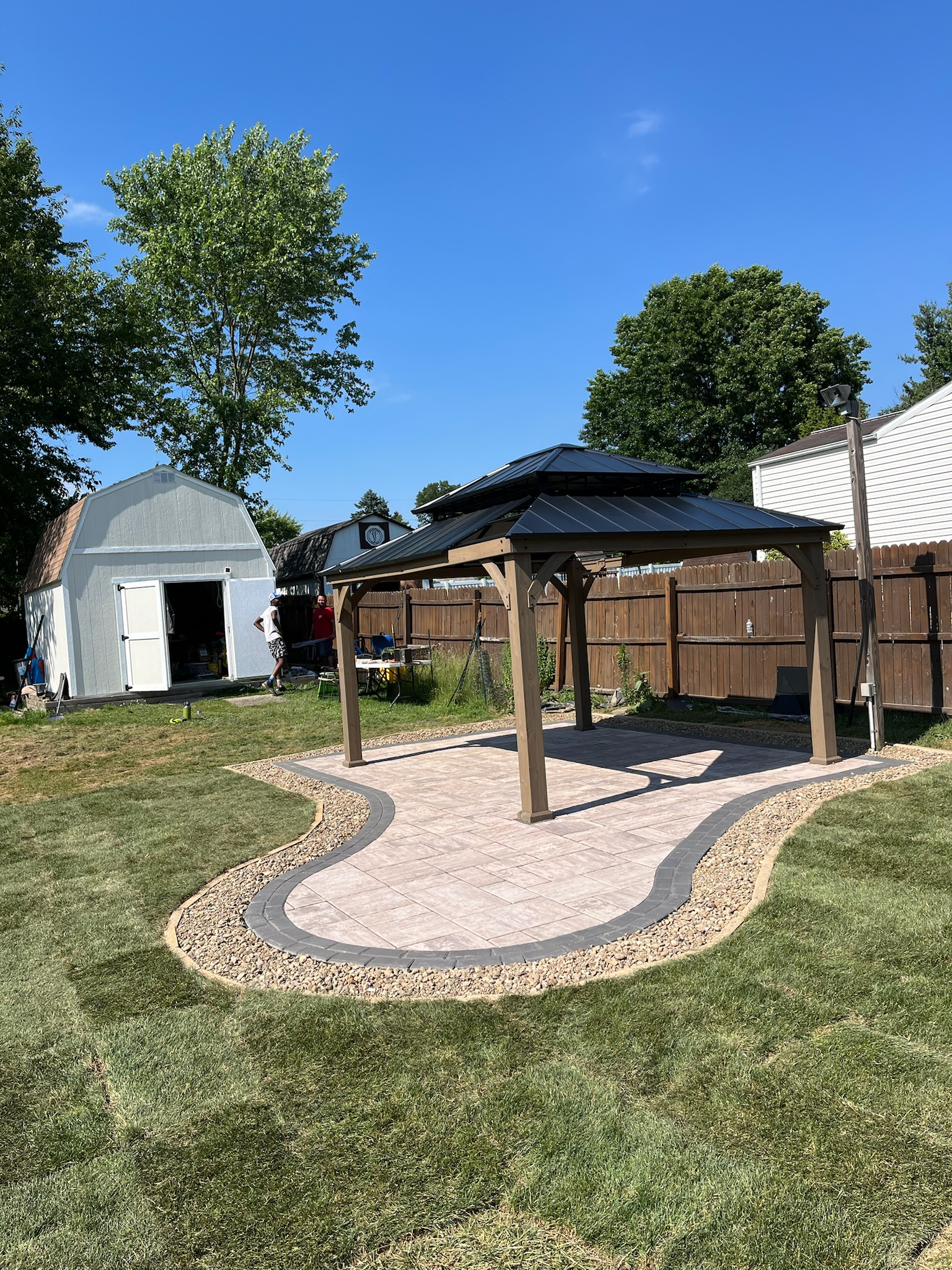 There is a gazebo in the middle of the backyard.
