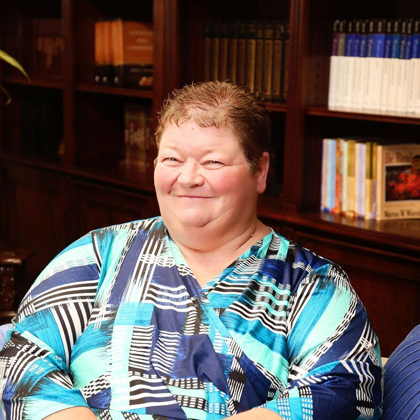 A woman wearing a watch is sitting on a blue couch