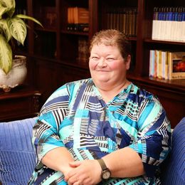 A woman wearing a watch is sitting on a blue couch