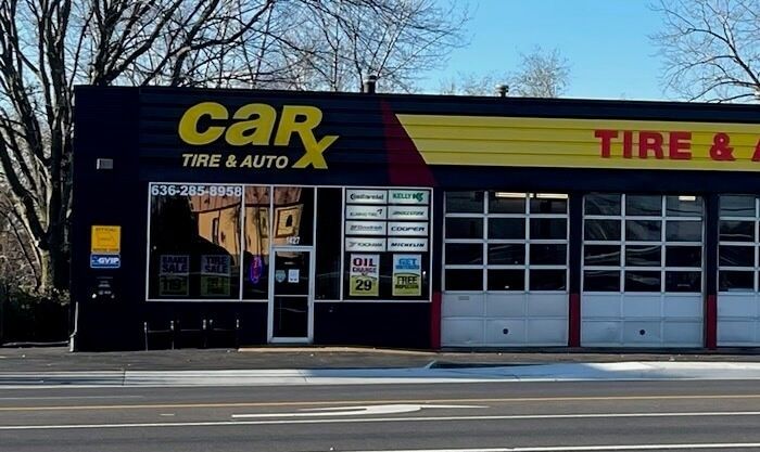 CarX Tire & Auto shop with black exterior, yellow logo, and garage doors.