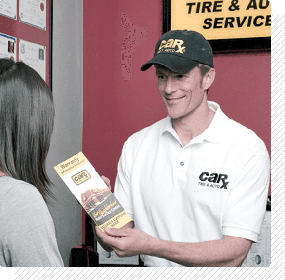 Man in CarX uniform hands brochure to customer in auto shop.