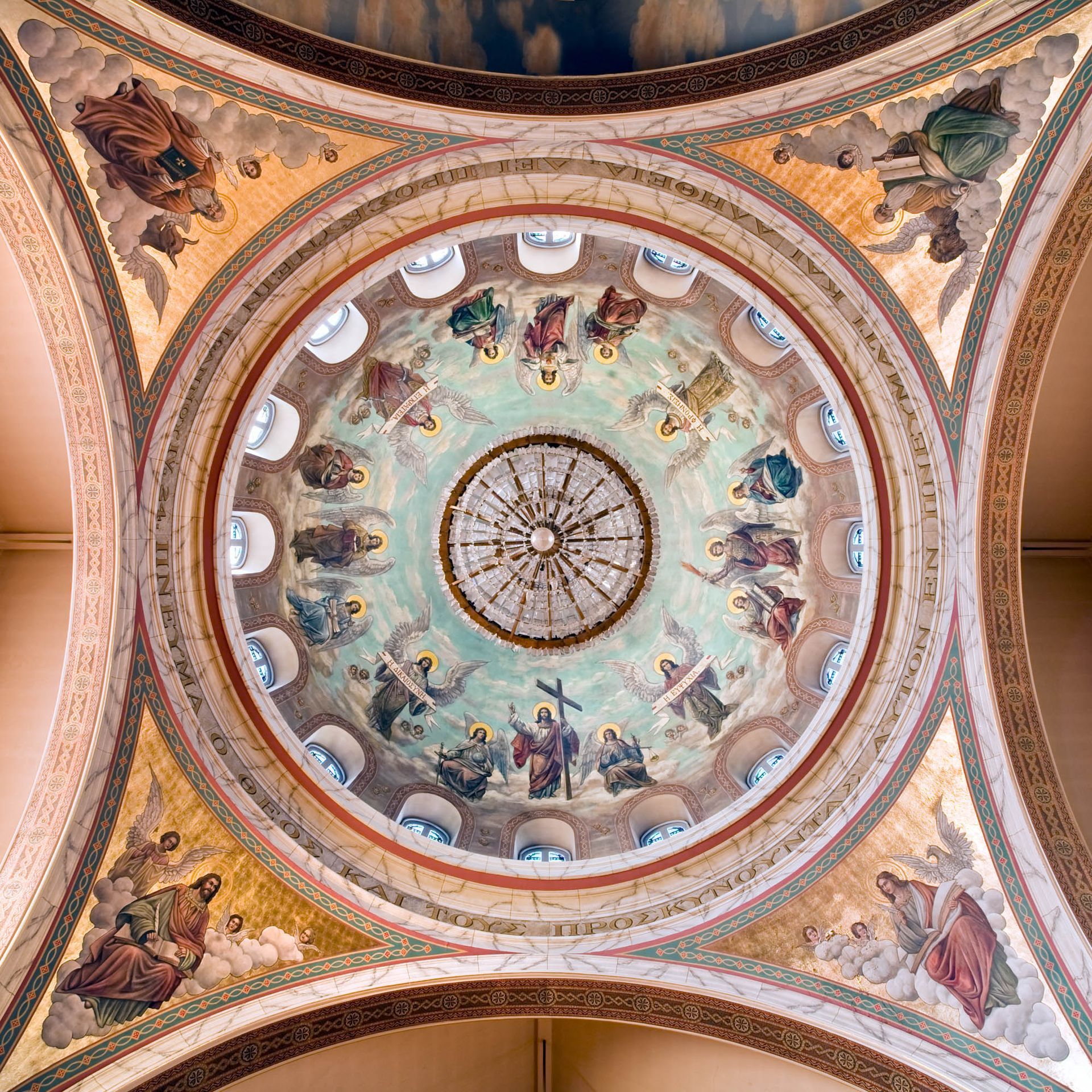 Symmetrical painted dome and chandelier in an ornate church interior