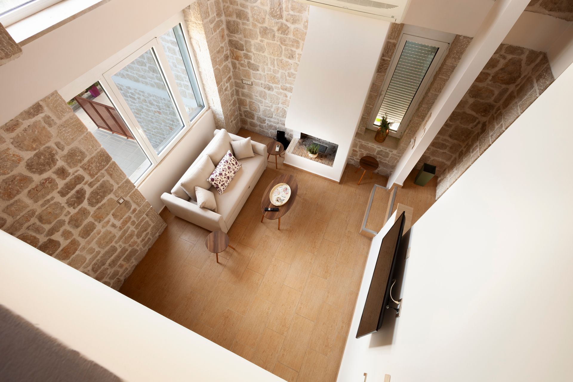 Overhead view into a double-height stone living room
