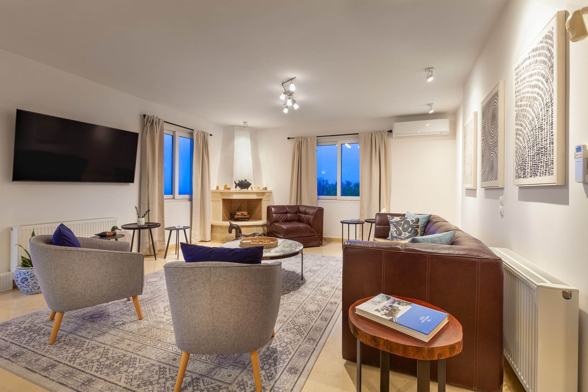 Warm living room at blue hour with layered seating and artwork