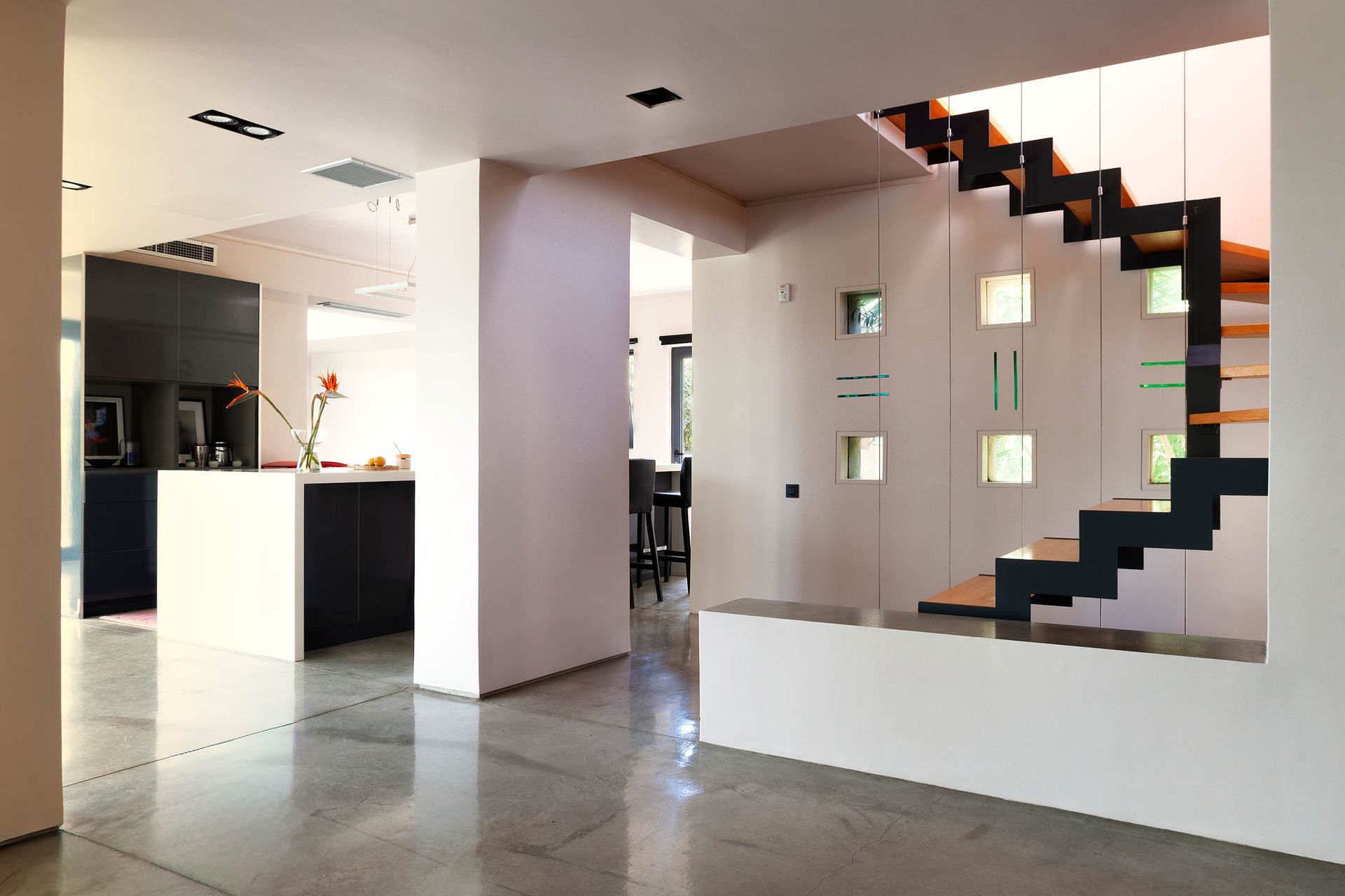 Contemporary open-plan interior with a graphic black staircase