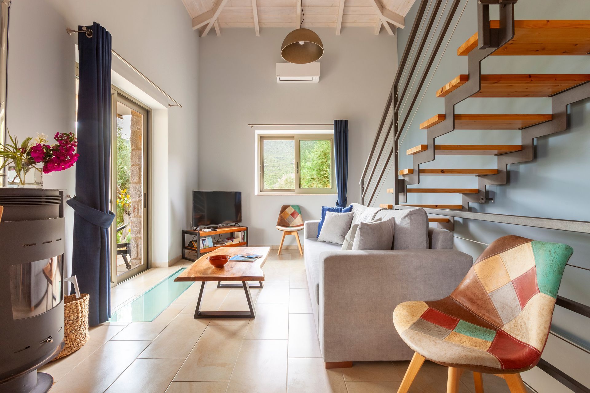 Blue living room organized around a floating timber staircase
