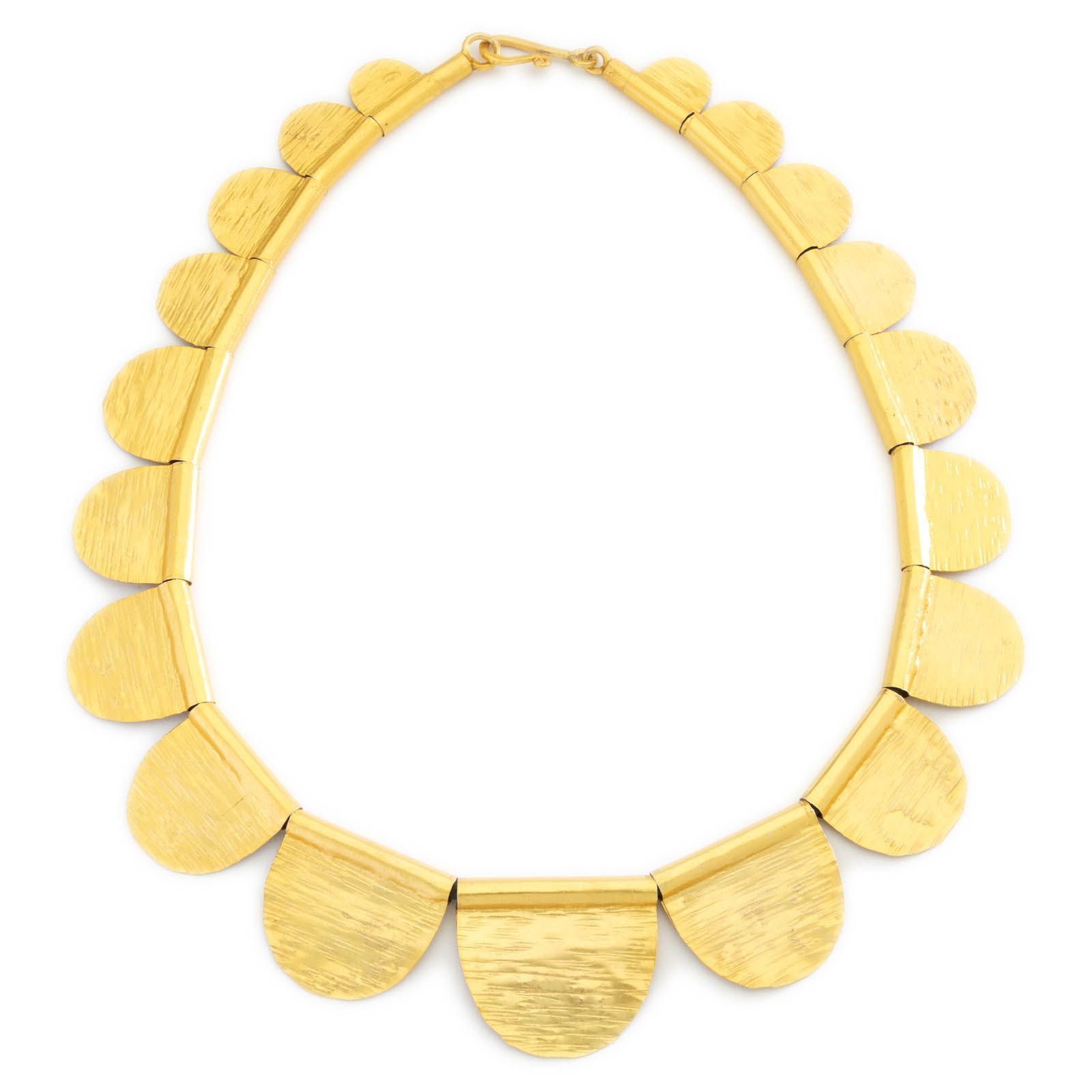 Gold statement necklace photographed on white
