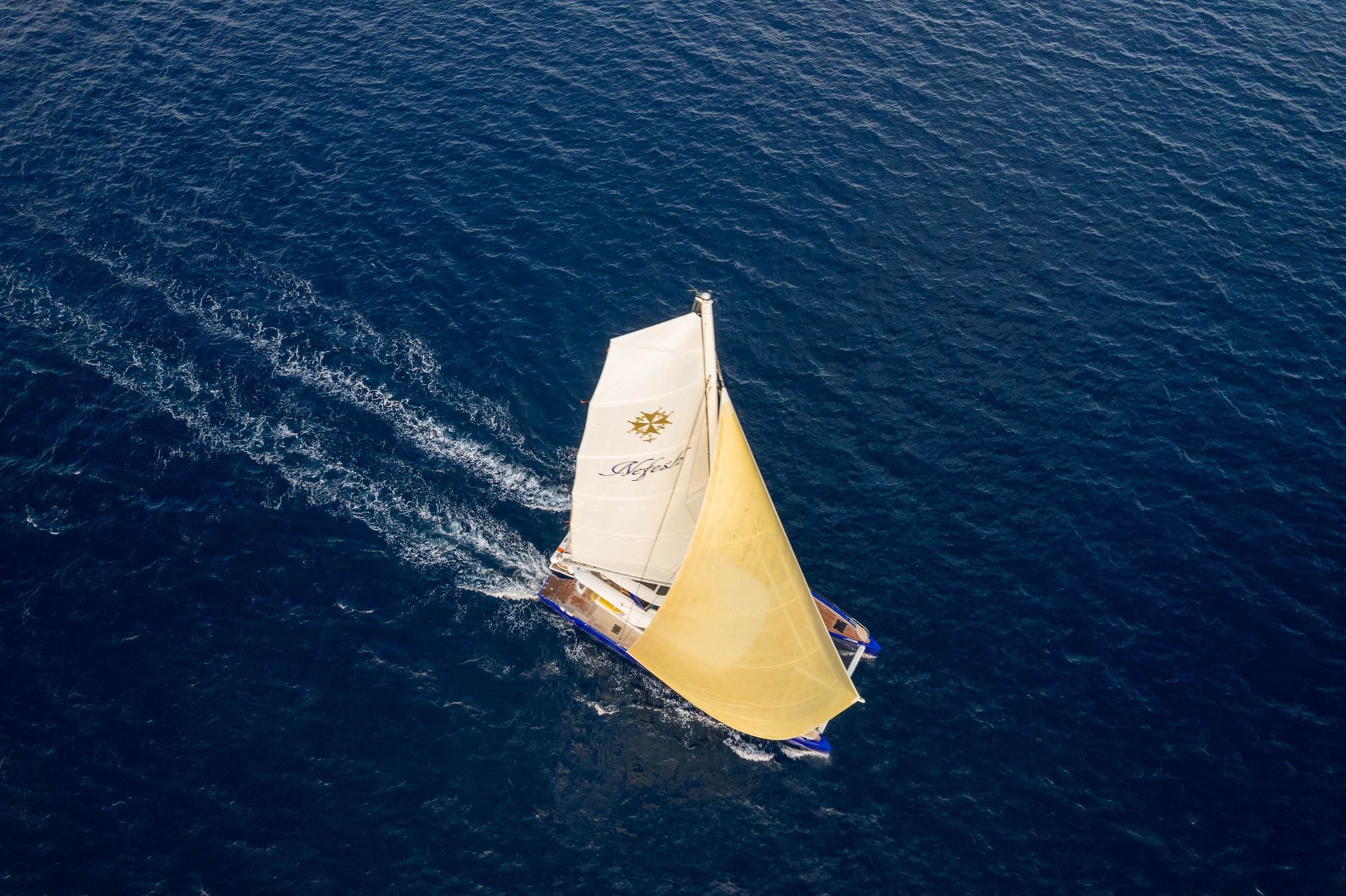 High oblique aerial view of the catamaran underway and its wake