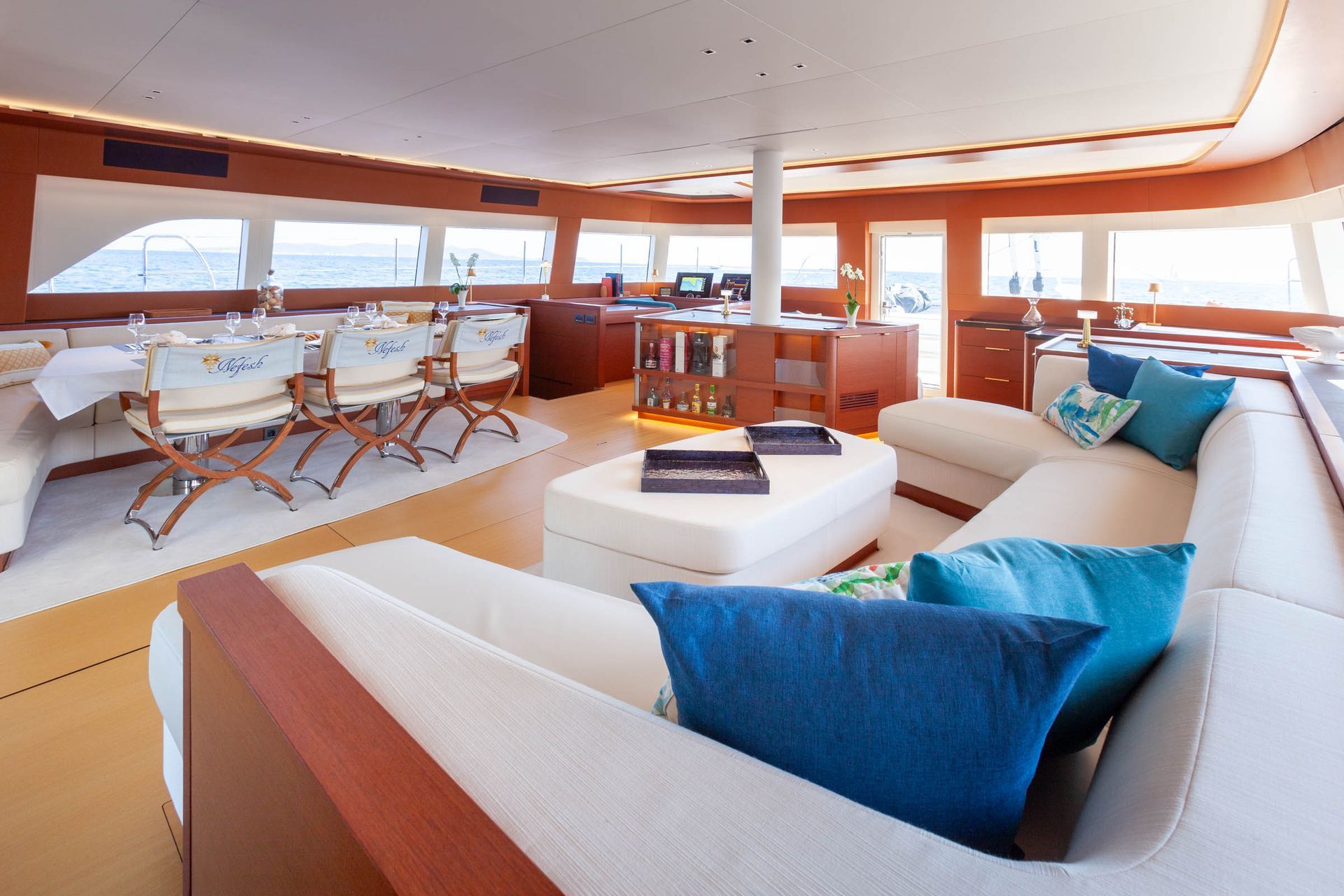 Warm timber main salon with curved seating and panoramic windows