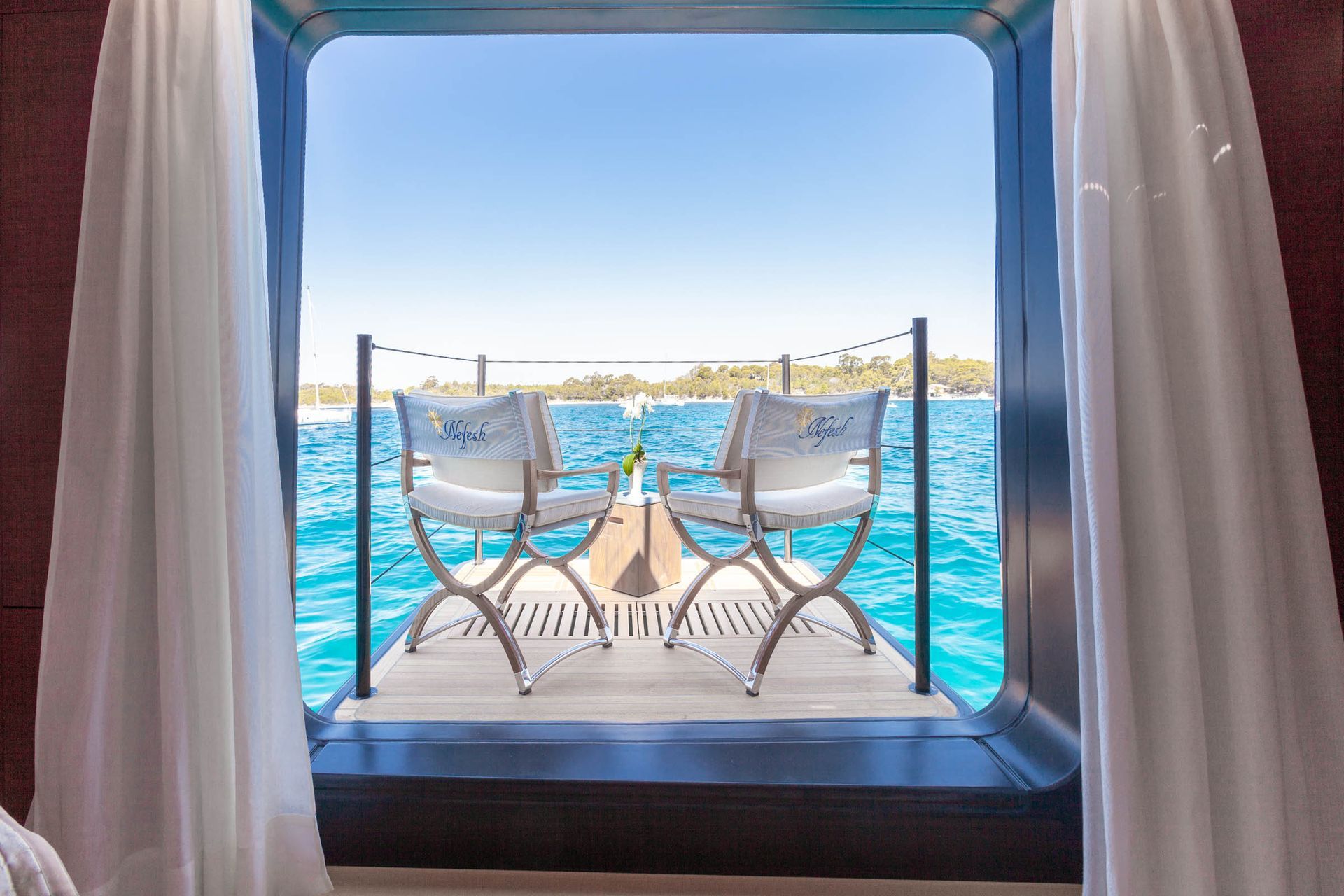 Guest seating framed by the yacht structure and the sea beyond