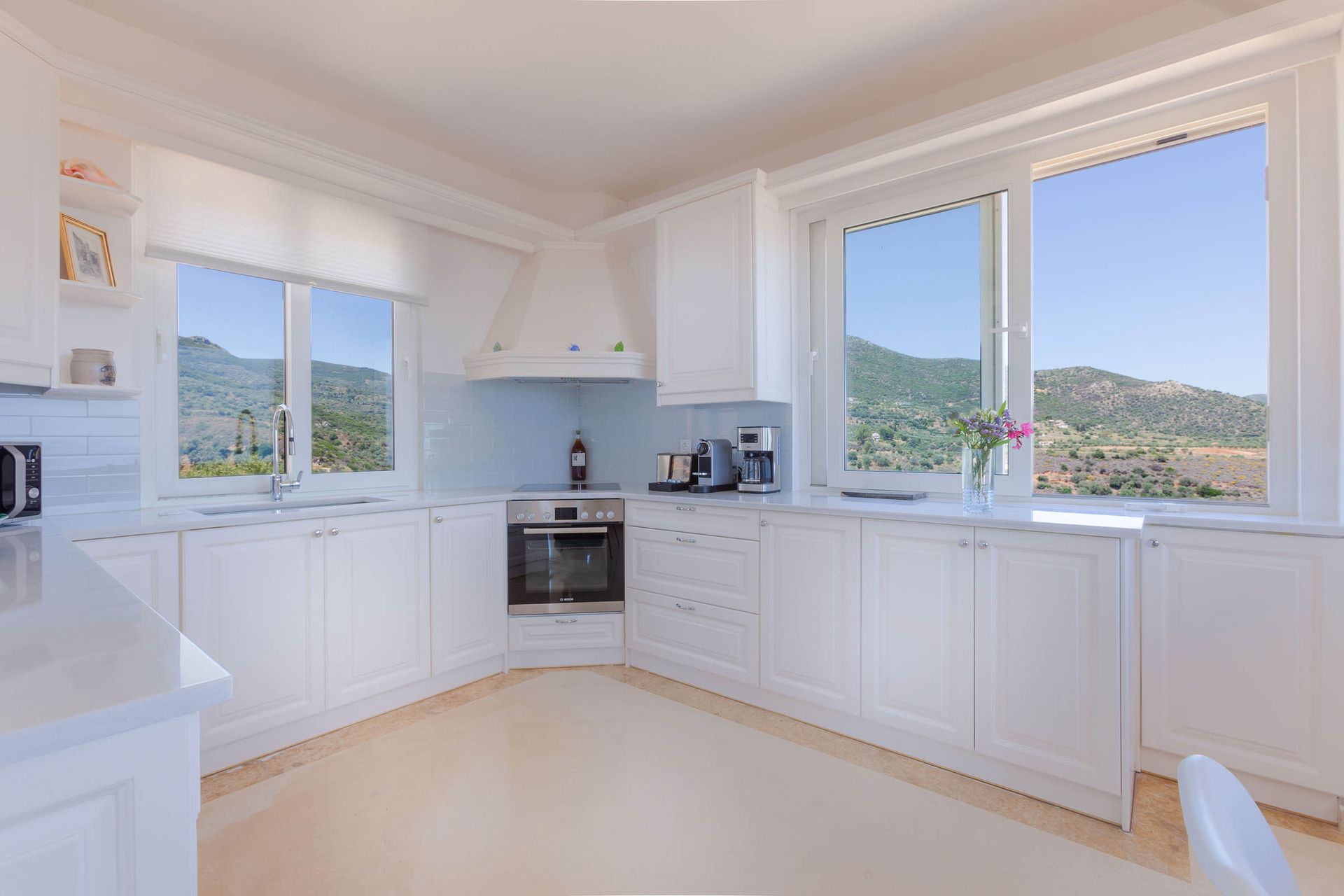 Bright white kitchen with views of the hills