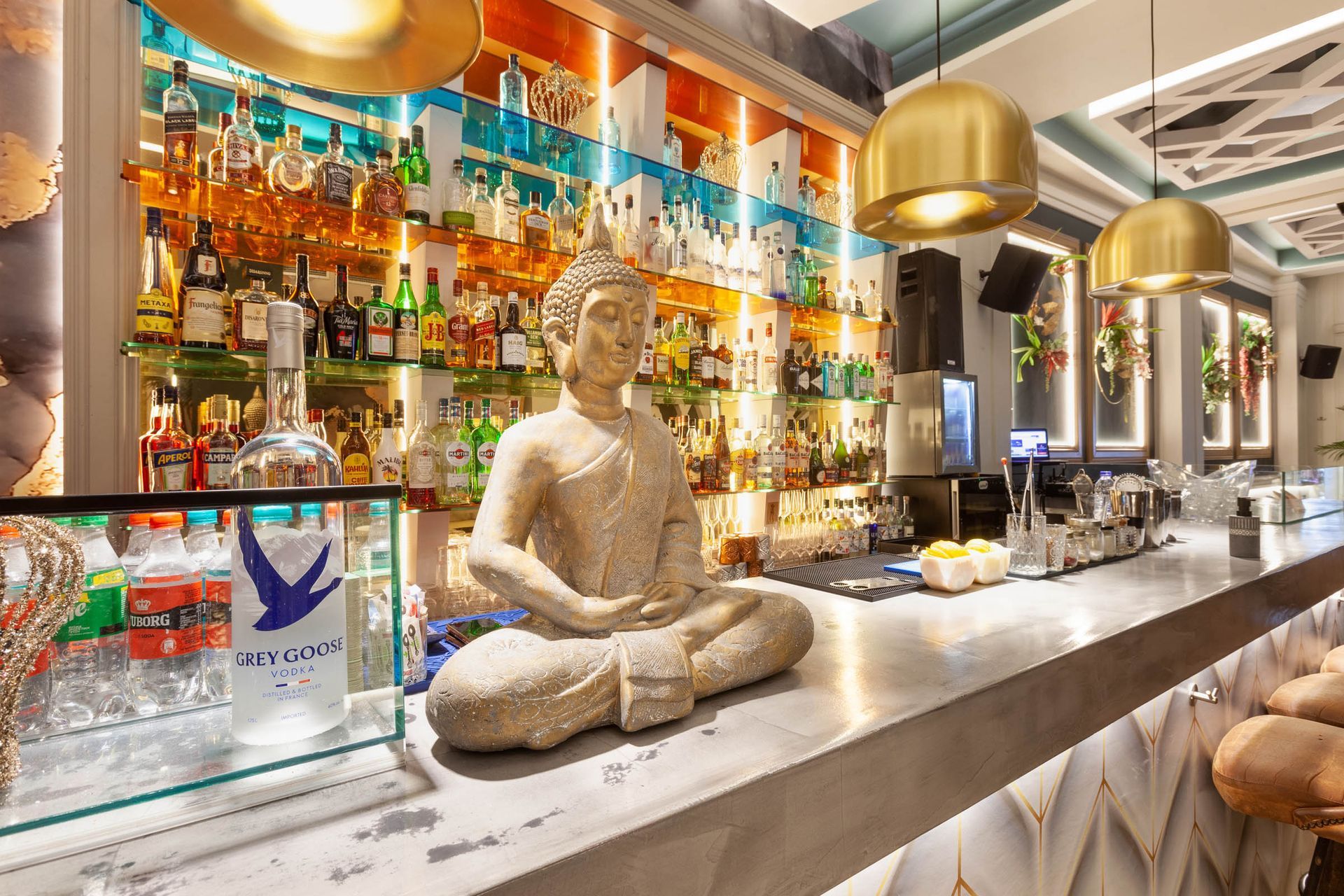 Back bar with bottles and a seated Buddha sculpture