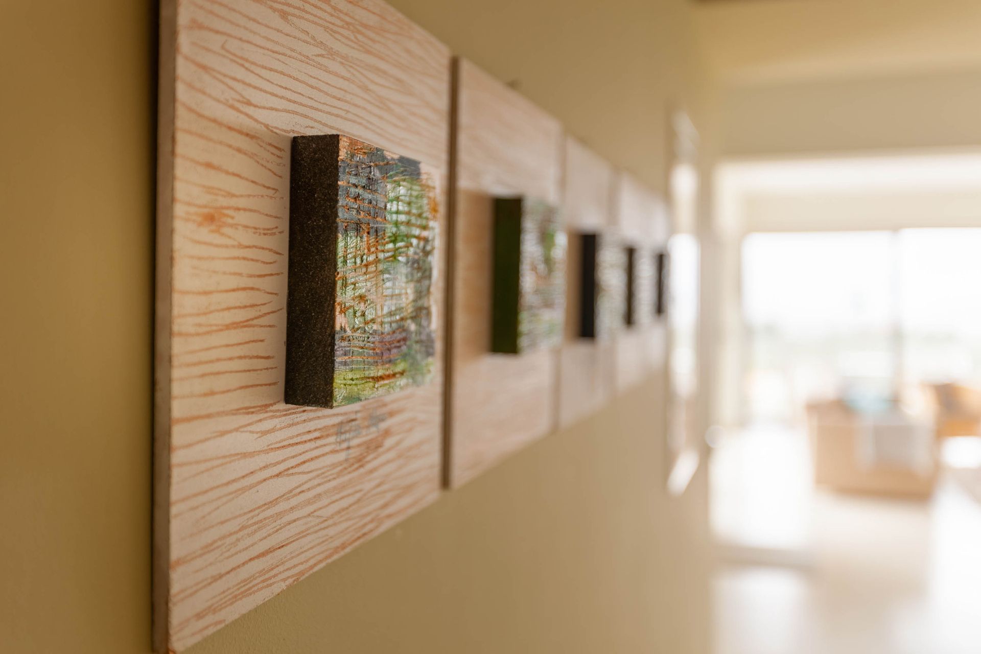 Framed artworks receding along a softly focused interior wall