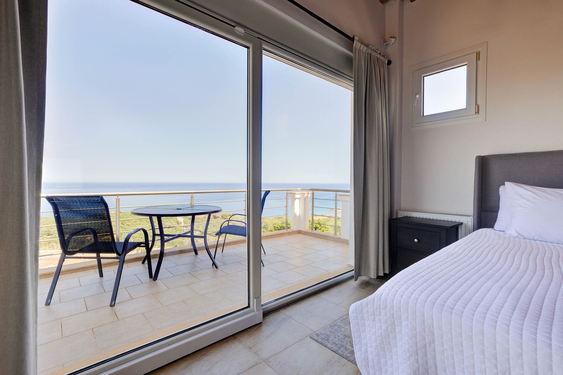 Sea-view guest bedroom opening onto a coastal terrace