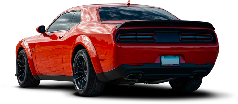 Red Dodge Challenger from rear at an angle, black wheels and spoiler, white background. | Auto Check Sugar Land