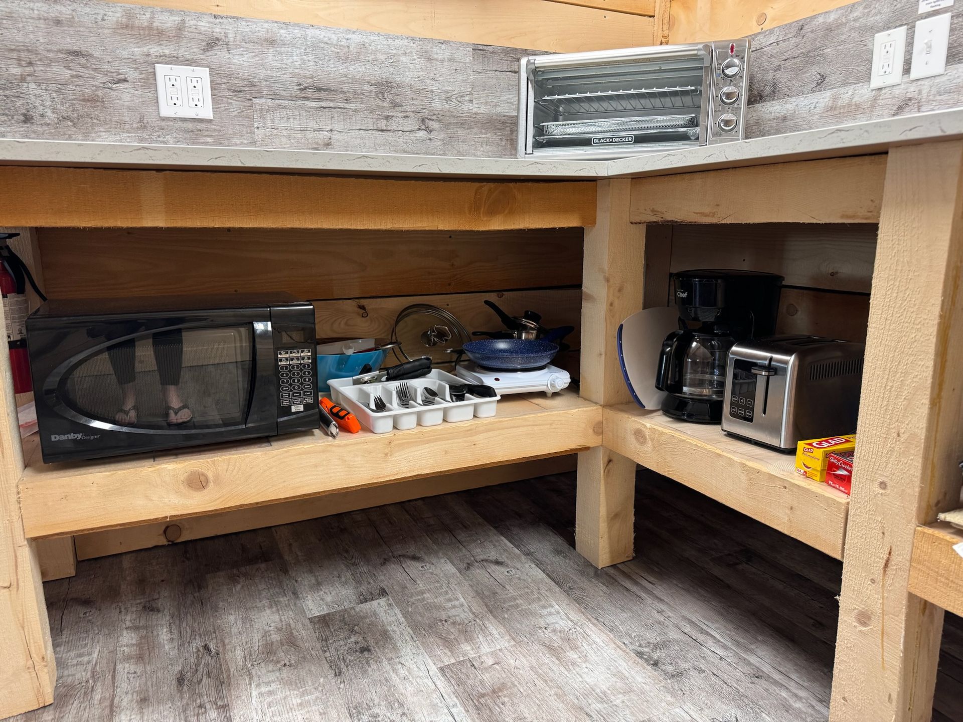 A kitchen with a microwave , toaster oven , coffee maker and other appliances.