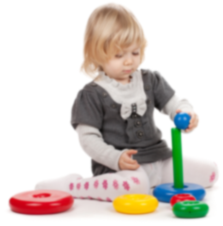 A toddler playing with a colorful stacking ring toy against a white background.