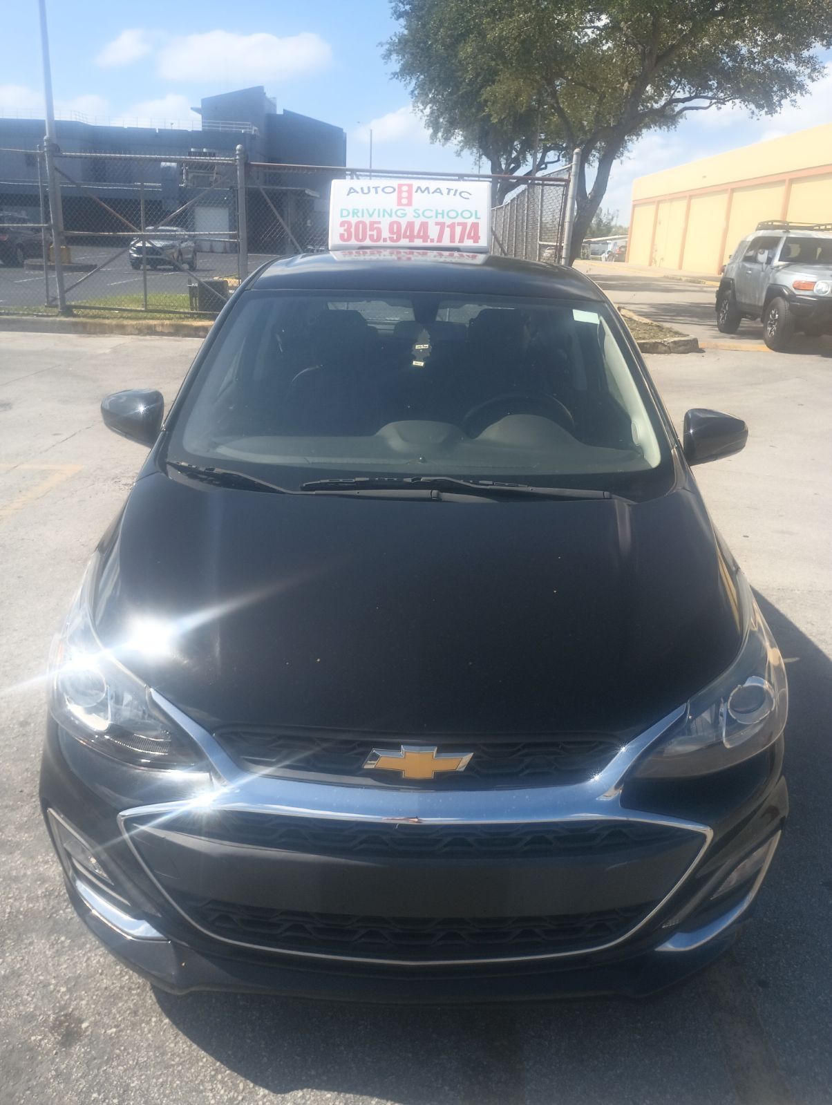 A black Chevrolet car is parked in a parking lot