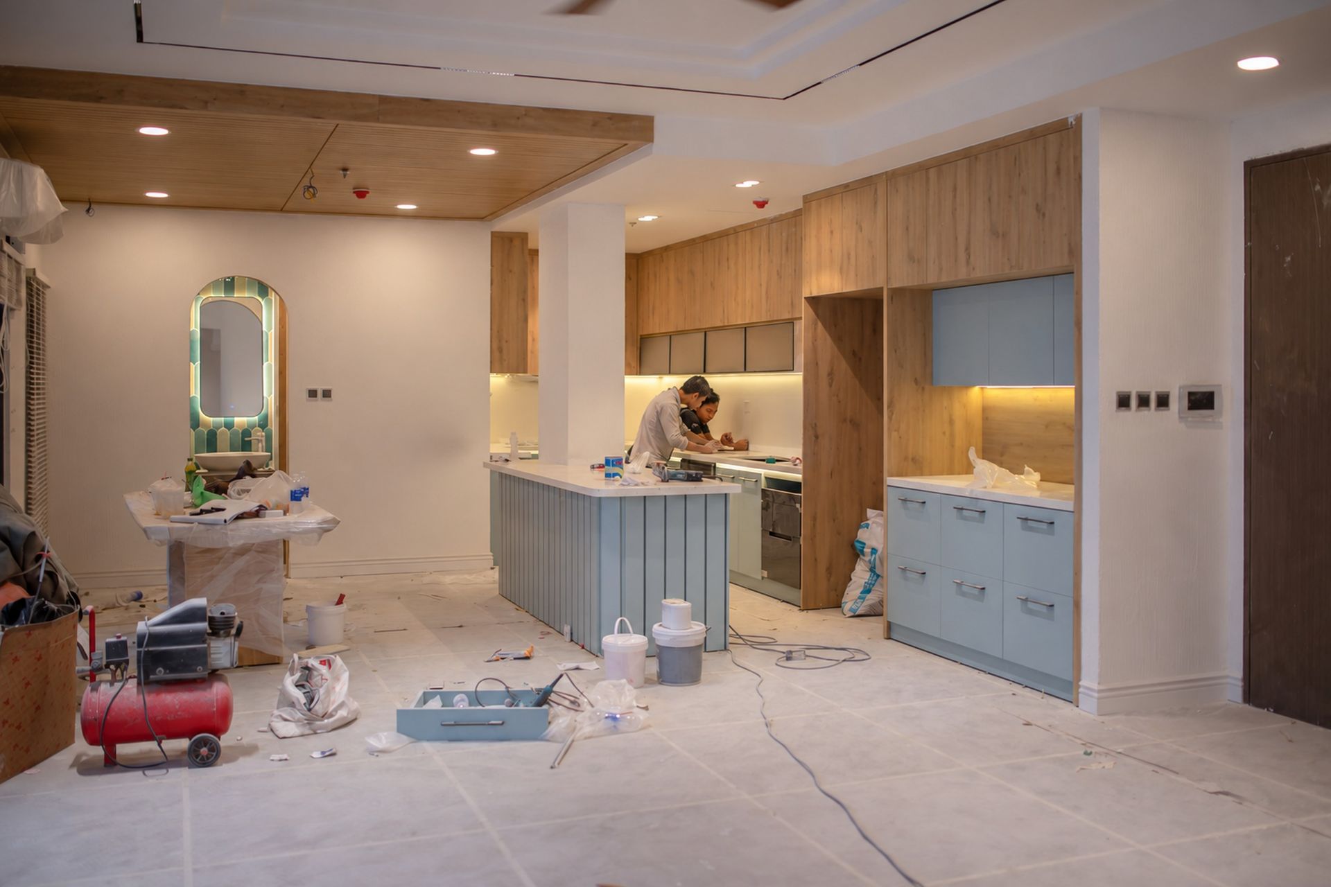 Interior finish work in a modern kitchen, with new cabinetry and countertops being installed