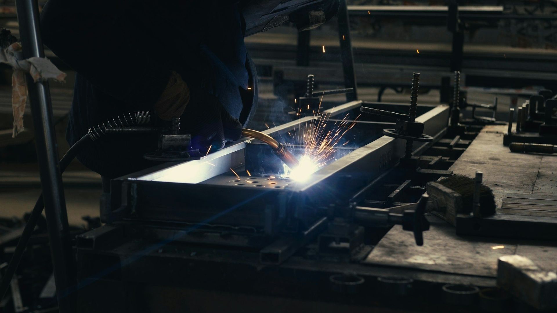 Welder fabricating metal in an industrial facility