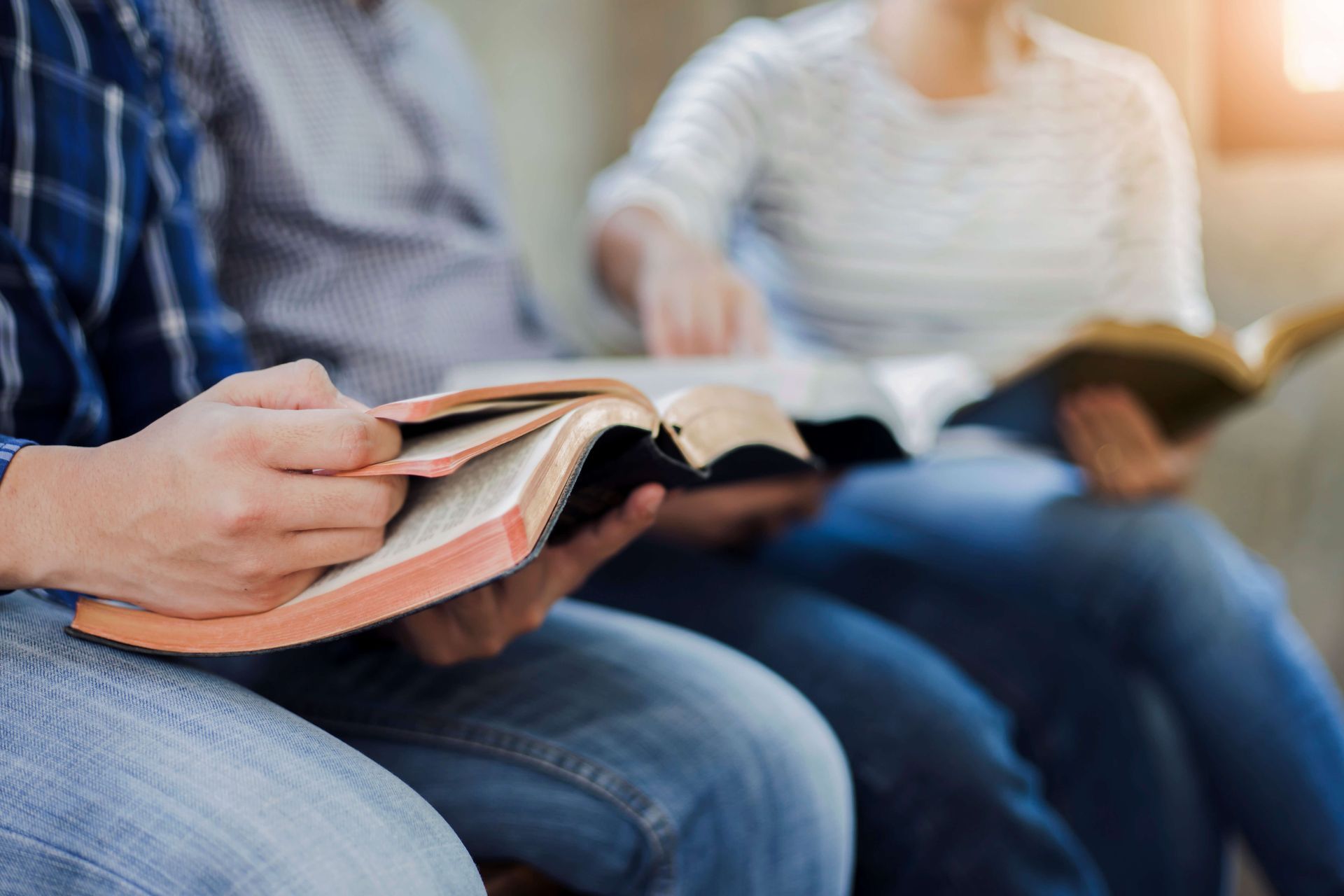 A group of people are sitting on a couch reading books