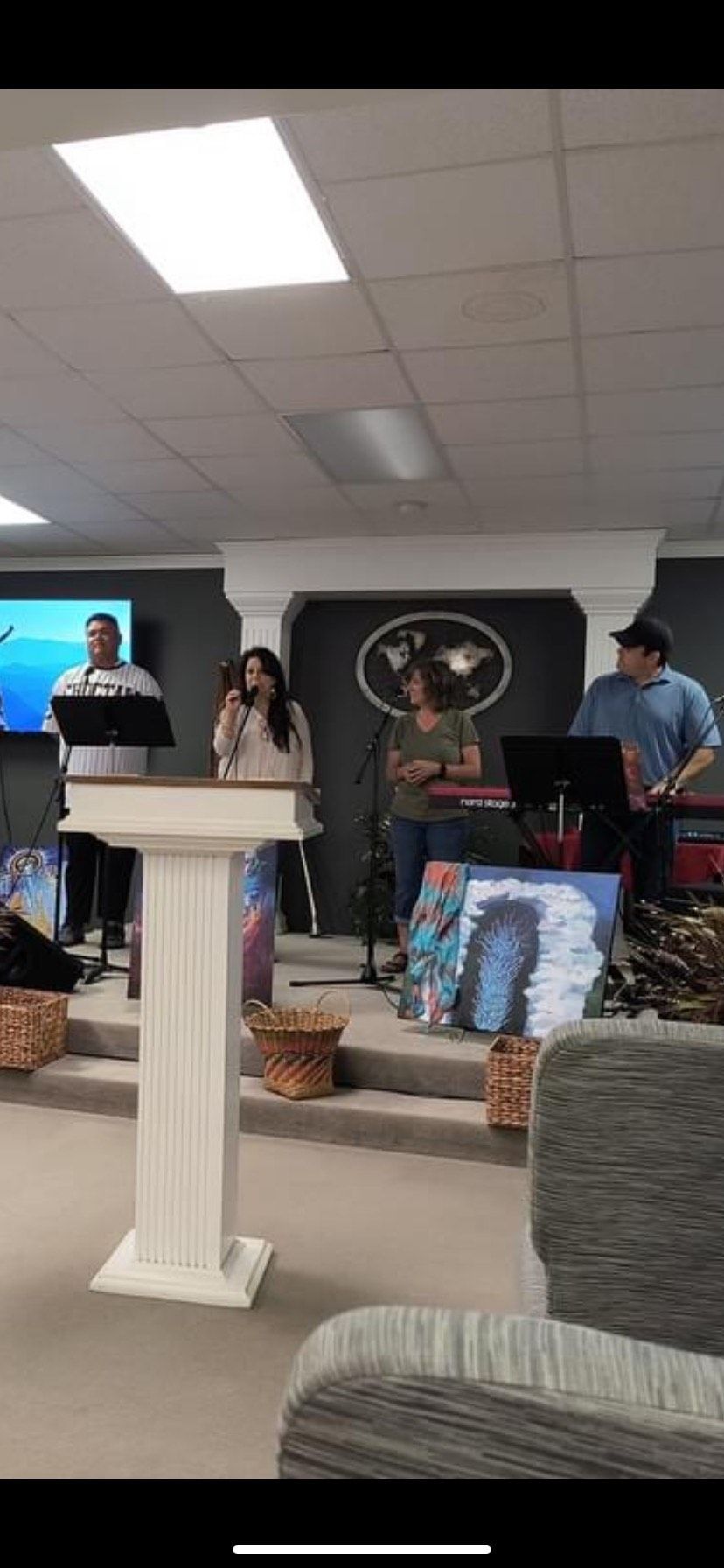 A group of people are standing around a podium in a church.