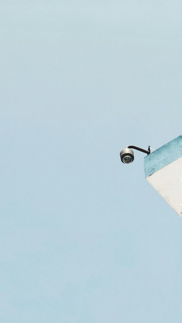 Skateboarder mid-air beside a blue-tiled ramp against a clear sky